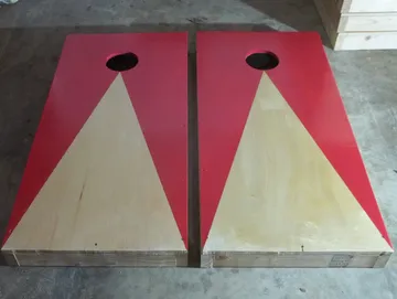 Red custom cornhole boards built and finished by Paul